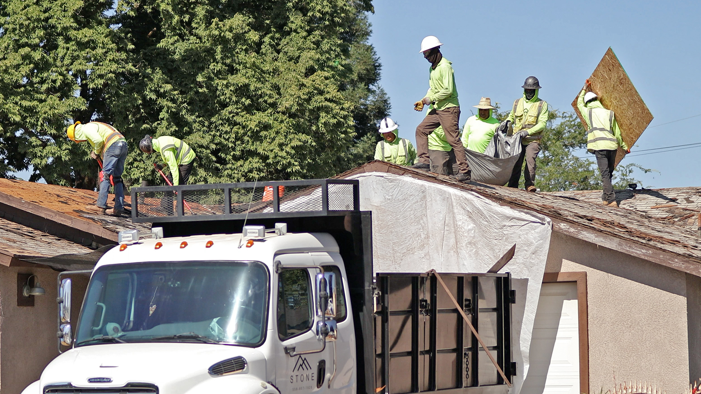 Roofing contractor performing an insurance claim inspection on a home with minor shingle damage